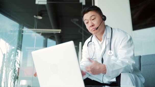 Asian Male Doctor Advises Patient Online Video Call Using Laptop — Vídeo de Stock