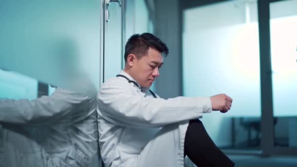 스트레스에 시달리는 아시아 의사가 병원의 복도에 있습니다 세계적으로 유행하고 위생국에서 — 비디오