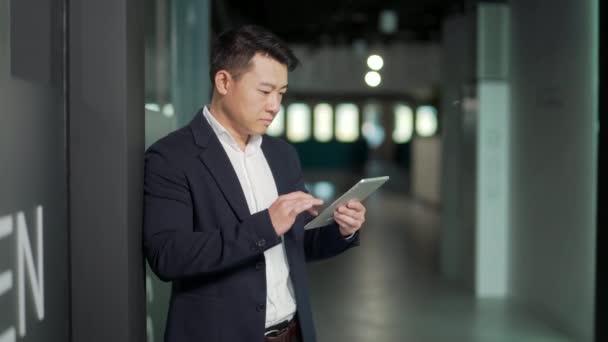 Ciddi Asyalı Erkek Işçi Modern Ofiste Tablet Bilgisayarla Çalışmaya Odaklanmış — Stok video
