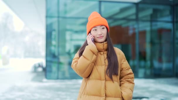 Mujer Asiática Joven Hablando Teléfono Móvil Caminando Día Nevado Invierno — Vídeo de stock