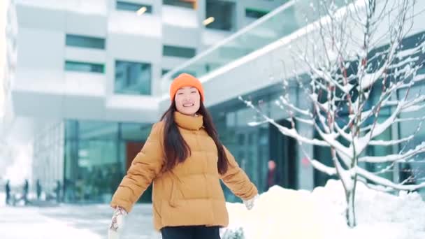 눈내리는 날씨에 도시의 거리를 활보하는 기쁨을 아시아인 여학생 배경에서 웃으며 — 비디오