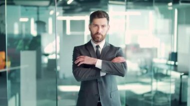 Portre başarılı, kendine güvenen beyaz sakallı, erkek ofis çalışanı. Kapalı alandaki resmi takım elbiseli kameraya bakıyor. Bir iş adamının ya da girişimcinin yüzü kollarını kavuşturdu. Modern camda