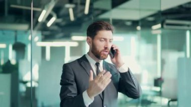 Ofiste cep telefonuyla konuşan kızgın kötü kalpli erkek işadamı. İş adamı içeride bağırıyor. Akıllı telefondan sinirli, profesyonel bir konuşma. Sinirli çalışan çalışan çığlığı.