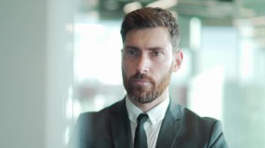 Modern bir ofis masasında bilgisayar üzerinde çalışan düşünceli bir erkek işadamı portresi. Takım elbiseli, dalgın, düşünceli bir iş adamı. Bir sorunu çözmek için ilham almayı düşünüyorum. Açılış