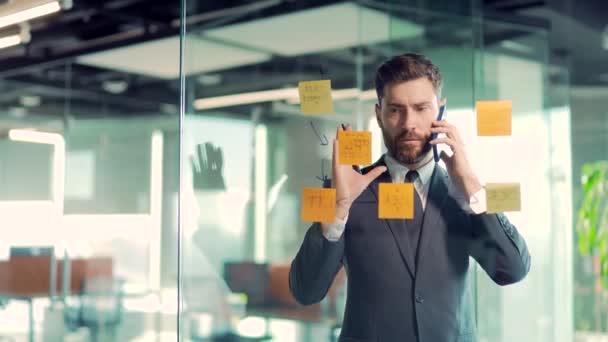 Hombre Negocios Hablando Por Teléfono Una Oficina Moderna Detrás Una — Vídeo de stock