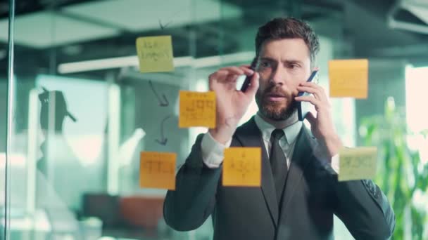 Hombre Negocios Hablando Por Teléfono Una Oficina Moderna Detrás Una — Vídeos de Stock