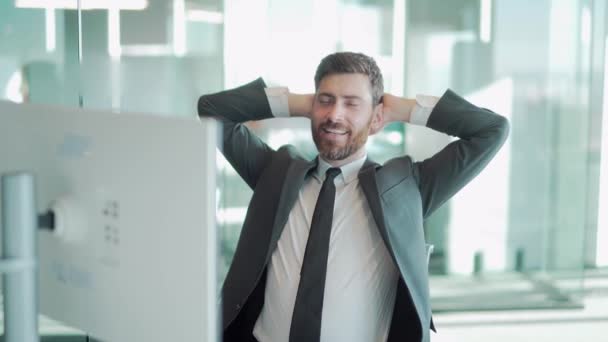 満足したサラリーマンは休暇の夢を見る 勤勉な一日の後にオフィスでリラックスした笑顔のビジネスマンは 職場でストレッチコンピュータ上のスーツ完成プロジェクトを身に着けています 笑顔幸せな最高経営責任者の目を閉じた — ストック動画