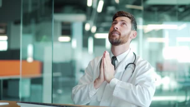 Doctor Prays Arms Raised Sitting Clinic Hospital — Stock Video
