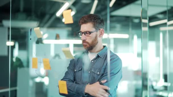 사무실의 창의적 사업가는 포스트잇 페이퍼를 사용하여 아이디어를 합니다 브레인스토밍 보드를 — 비디오