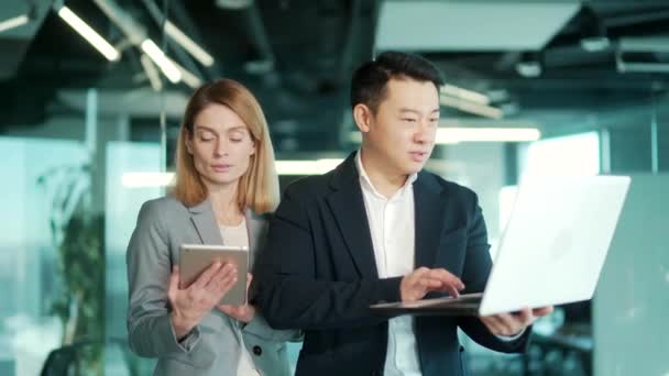 Dwóch Wielonarodowych Azjatyckich Kolegów Rozmawiających Podczas Pracy Nad Tabletem Cyfrowym — Wideo stockowe