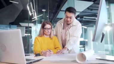 Yaratıcı insanlardan oluşan çok ırklı bir ekip bir projeyi tartışıyor. Karışık yarış mühendisleri, mimarlar modern çalışma alanındaki planlar üzerinde ortak proje çalışmaları için işbirliği yapıyorlar. Asyalı erkek kadın