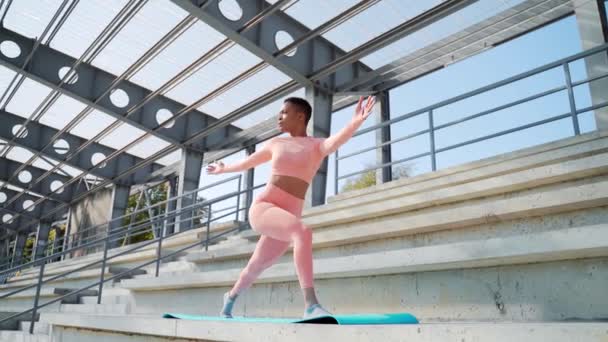 Mladá Afroameričanka Růžovém Sportovním Oblečení Cvičí Jógu Podložce Městském Stadionu — Stock video