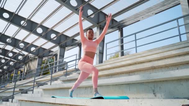 Mladá Afroameričanka Růžovém Sportovním Oblečení Cvičí Jógu Podložce Městském Stadionu — Stock video