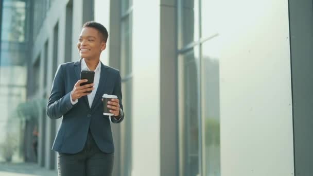 Щаслива Чорношкіра Жінка Яка Посміхається Йде Міській Вулиці Мобільним Телефоном — стокове відео