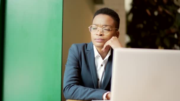 非洲裔美国女性坐在咖啡店里思考 一位严肃而沉思的商业女性凝视着窗外 女企业家坐着 启动和案件解决 — 图库视频影像