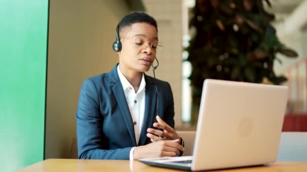 Mujer Afroamericana Seria Utiliza Auricular Para Una Videollamada Trabaja Café — Vídeos de Stock