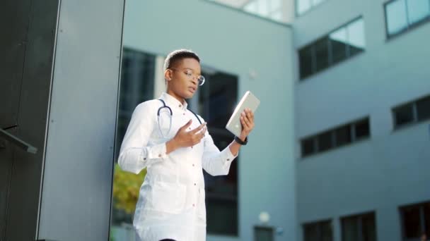 Doctora Afroamericana Hablando Línea Asesorando Remotamente Paciente Usando Tableta Digital — Vídeos de Stock