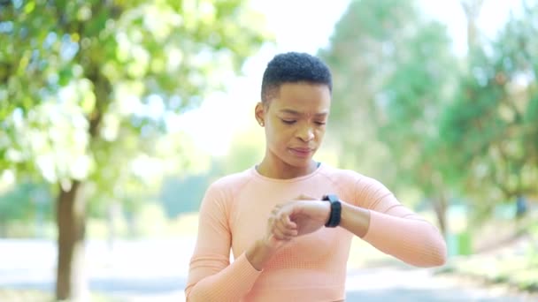 Αθλητική Αφροαμερικανή Γυναίκα Που Δείχνει Έξυπνο Ρολόι Στη Σύγχρονη Πίστα — Αρχείο Βίντεο
