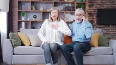 Yaşlı çift kalp krizi ambulans çağrısı. Olgun bir adam, koca acil servisi arıyor ya da doktor, kadın, karın kalp ağrısı çekiyor. Göğüste nefes darlığı.