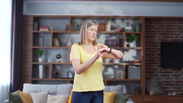 Active Woman Senior Female Uses Smart Watch While Training Home — Vídeo de stock