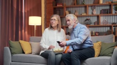 Kaygısız gri saçlı yaşlı çift, televizyon kumandası ile televizyon izlemek ve kanalları değiştirmek için bir dizi seçiyor. Aile bir gösteri seçemez. Zor seçim, izlenecek bir şey yok.