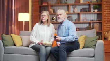 Mutlu son sınıf çifti, spor müsabakalarını izlerken televizyon oyunu izlerken evdeki oturma odasındaki kanepede zaferi kutluyor. Olgun aile futbolu hayranları, aile eğlencesi