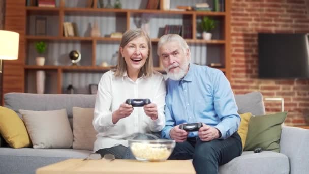 Pareja Mayor Jugando Consola Videojuegos Con Joysticks Sentado Sofá Sala — Vídeos de Stock