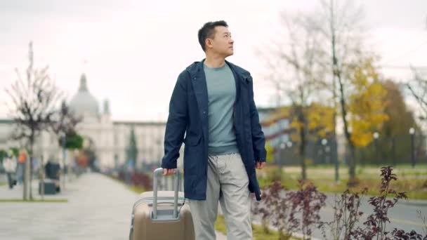Azjatycki Turysta Jedzie Torbą Lub Ciągnie Walizkę Ulicą Człowiek Przybywający — Wideo stockowe