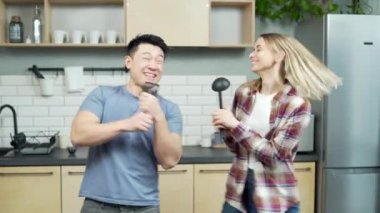 Neşeli, komik bir çift mutfakta dans edip şarkı söylüyor. Asyalı adam ve kadın evde dans ediyorlar. Genç bir aile birlikte vakit geçiriyor. Yeni eve taşınmayı kutluyoruz. Neşeli karı koca birlikte yemek pişiriyor.