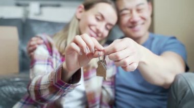 Portre gururlu, genç, yetişkin sahipleri yeni dairelerinde anahtarlarını tutan bir çift. Gülümseyen Asyalı karı koca. Aile kameraya bakarak yeni bir ev. mortgage yatırım kavramı Kapat