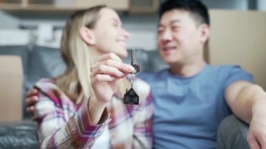 Portre gururlu, genç, yetişkin sahipleri yeni dairelerinde anahtarlarını tutan bir çift. Gülümseyen Asyalı karı koca. Aile kameraya bakarak yeni bir ev. mortgage yatırım kavramı Kapat