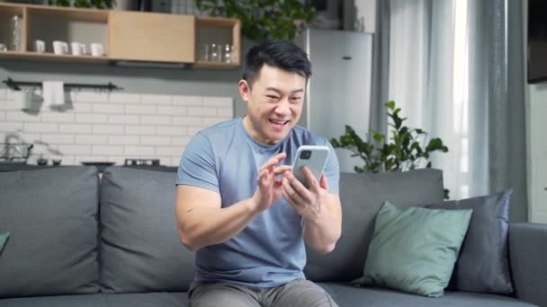Glücklicher Asiatischer Mann Der Auf Sein Handy Schaut Freut Sich — Stockvideo