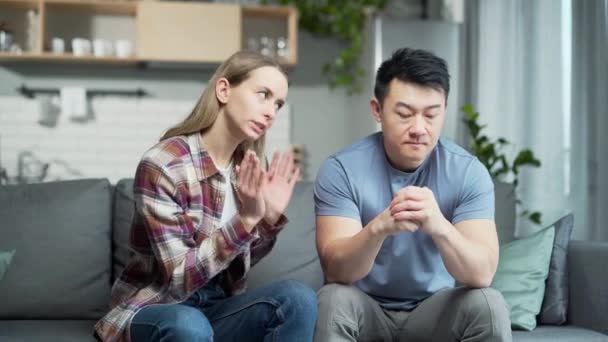 Ženy Které Hádají Manželem Nervózní Asiat Sedící Gauči Popředí Zatímco — Stock video