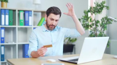 Ofisteki dizüstü bilgisayarda online ödeme hatası yapan bir işadamı. Erkek ofis çalışanı kredi kartıyla sorun yaşıyor. İş yerinde oturan bir girişimci.. 