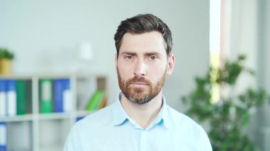 Portre yakışıklı beyaz sakallı ofis çalışanı, çalışan, kameraya bakan girişimci, gülümseyen. - Yakın çekim. İşteki neşeli erkek kâtip. Modern bir iş ofisinde iş adamı. Kapat.