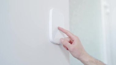 Adam kapıyı açmak için güvenlik şifresine basıyor. İşadamı parmak şifresi kodunu alarm paneline giriyor, erkek kolunu içeride kapatıyor. Ofis binası, apartman.