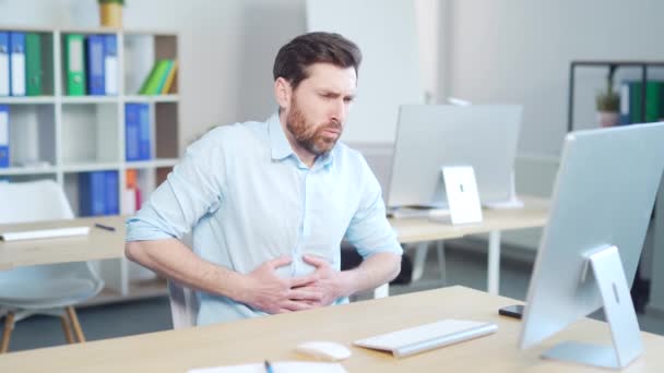 激しい腹痛 胃の痛み 職場に座ってハンサムな 原因アジアの男性従業員起業家 屋内だ パソコンのデスクで胃の痛みを抱えているサラリーマン — ストック動画