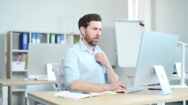 İş yerinde masa başında oturan sıradan bir iş adamı, kliması yok. Sıcaktan acı çeken erkek ofis çalışanı alnını siler. İşteki bir adam. Sıcak yaz havası. Kapalı