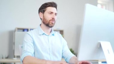 Yakışıklı bir erkek menajer ya da çalışan bir girişimci görüntülü konuşma yapıyor. İş toplantısı ya da uzaktan konferans. Bir çalışan, modern bir ofisteki bir bilgisayar masasında oturuyor.