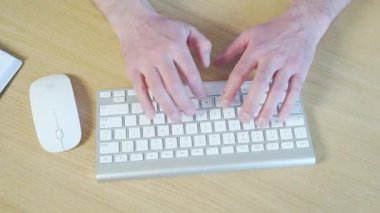 Bir iş adamının ellerinin klavyeye masa yazarken yakın çekimi. Ofisteki bilgisayarda çalışan bir adam, yakın plan. Üst görünüm