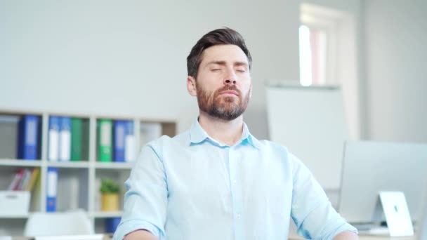 男性労働者は目を閉じてリラックスし 深呼吸をします 部屋の中で冷たくて新鮮な空気を楽しんでいます 社内の職場で仕事をしている 男性従業員起業家コンピュータデスク — ストック動画