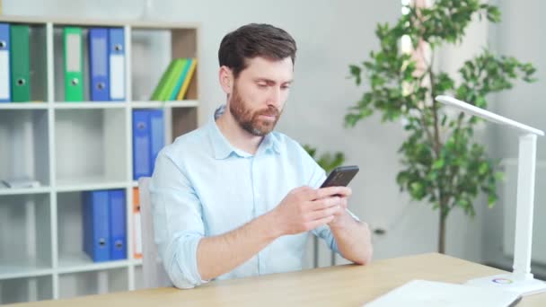 Glad Manlig Kontorsarbetare Läser Goda Nyheter Mobiltelefon Bläddrar Bland Sociala — Stockvideo