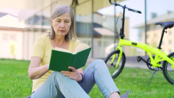 Eine Seniorin Liest Auf Einer Wiese Stadtpark Ein Buch Draußen — Stockvideo