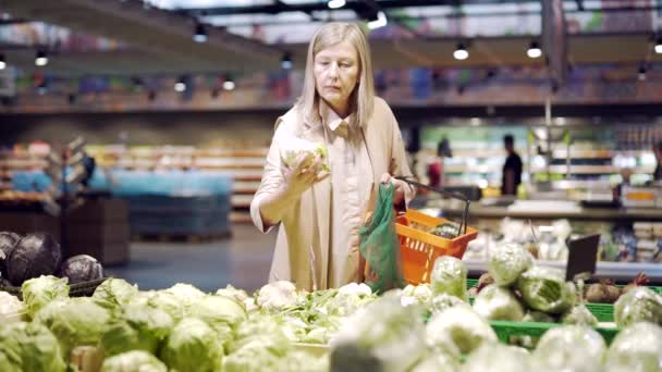 Mulher Sênior Escolhe Escolhe Legumes Coloca Saco Ecológico Frutas Supermercado — Vídeo de Stock