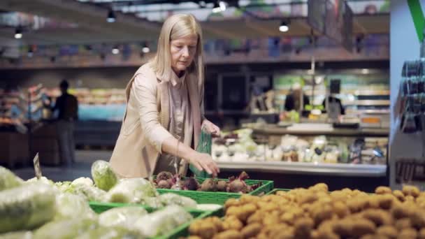 Mulher Sênior Escolhe Escolhe Legumes Coloca Saco Ecológico Frutas Supermercado — Vídeo de Stock