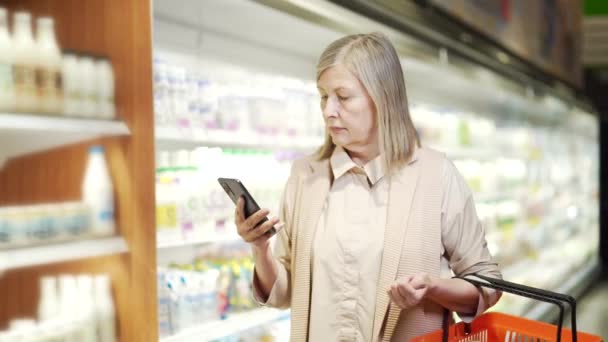 Yaşlı Olgun Bir Kadın Alıcı Akıllı Telefon Kullanarak Alışveriş Listesini — Stok video