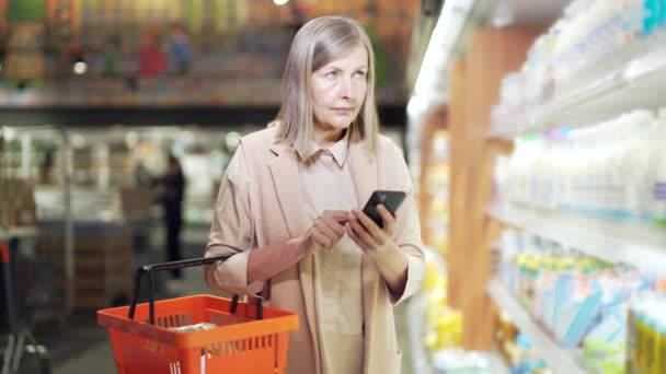 Ältere Reife Frau Käuferin Checkt Einkaufsliste Smartphone Kauft Supermarkt Ein — Stockvideo