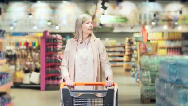 Старшая Счастливая Женщина Толкающая Тележку Проводит Время Супермаркете Продуктовом Магазине — стоковое видео