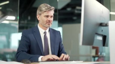 Bilgisayarda çalışan olgun sakallı işadamı çalışanı başarılı EVET Jesti 'ni kutluyor. Ilımlı ofiste çalışmak Şans Vuruşu, Büyük Kazanır. Kıdemli işçi zaferi İyi haber finansal anlaşma