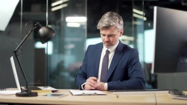 Kıdemli iş adamı ofiste bir onay belgesi imzalıyor. Olgun gri bankacı ya da avukat işadamı. İş ortaklığı sözleşmesi okuyup imzalıyor. Çalışan evrak işi yapıyor